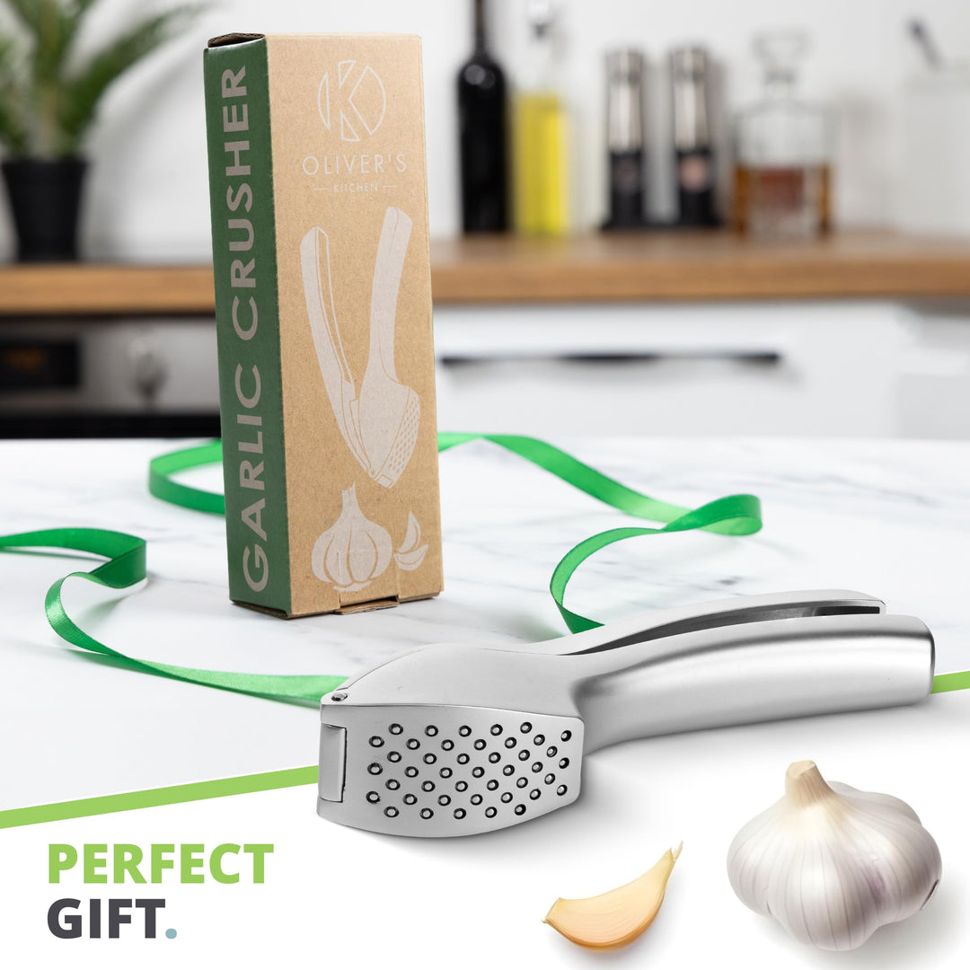 Garlic press and box - a perfect kitchen gift, shown with garlic cloves on the worktop